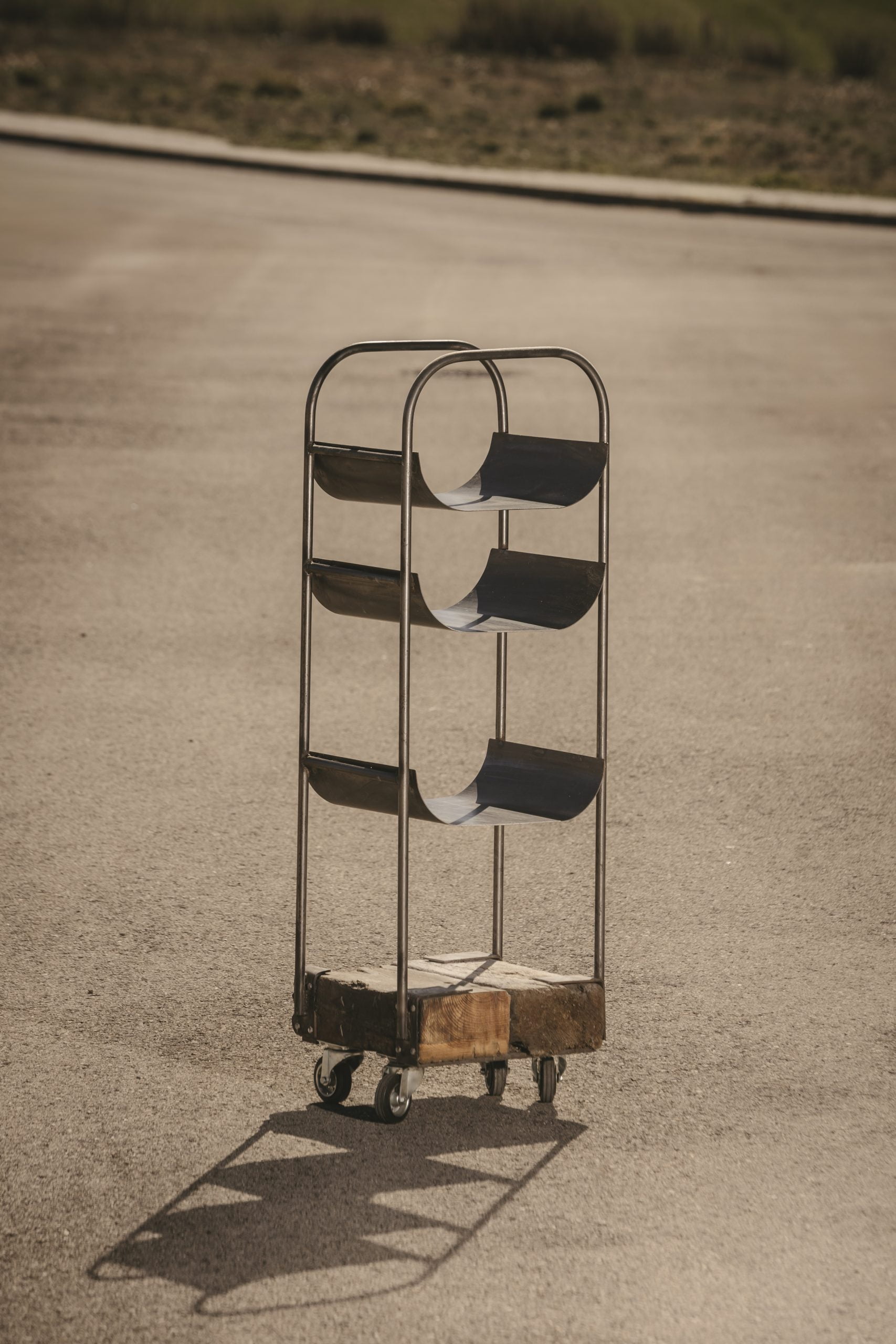 Leñero artesanal de madera y metal.